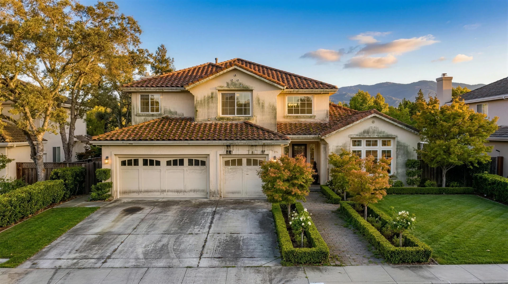 San Jose home before pressure washing — algae streaked stucco and stained driveway